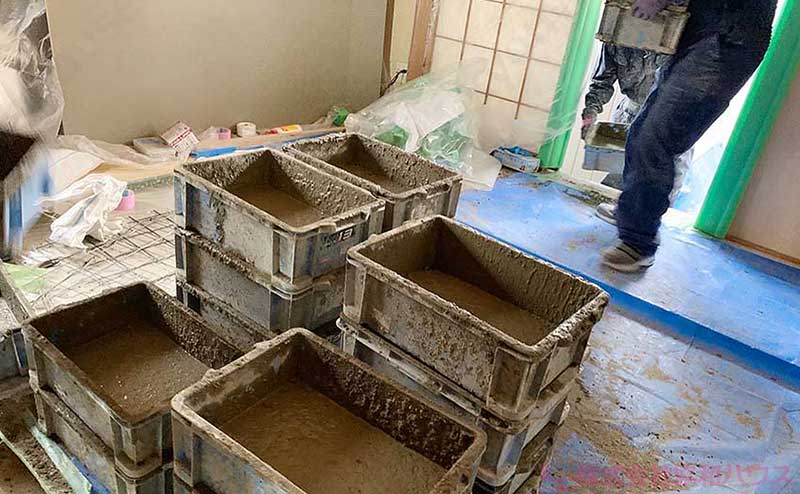 コンクリートを入れたケースを床下付近まで運び込み作業