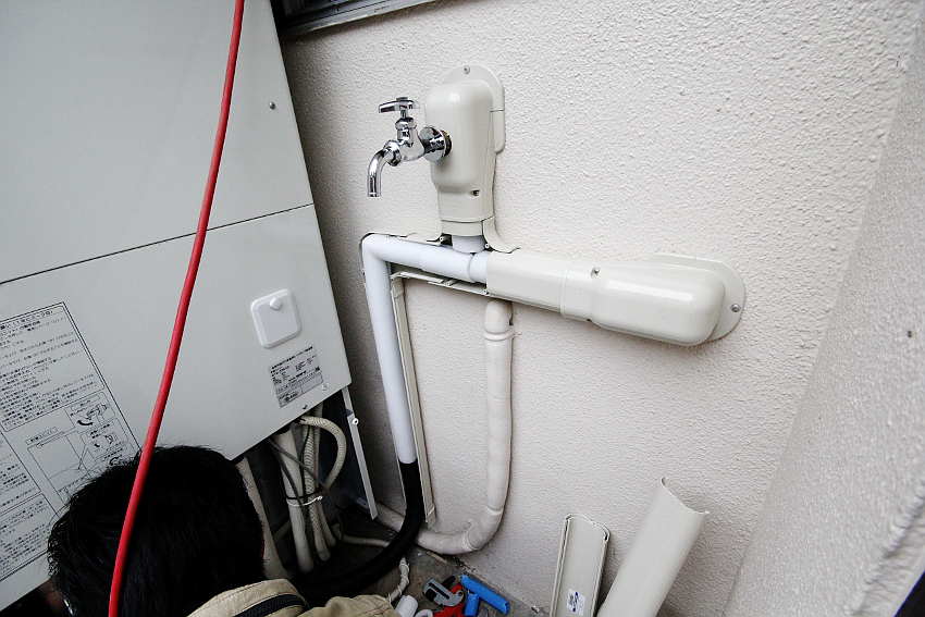洗面部分の配管カバーから出ている配管にキャンパステープを巻きつけ
