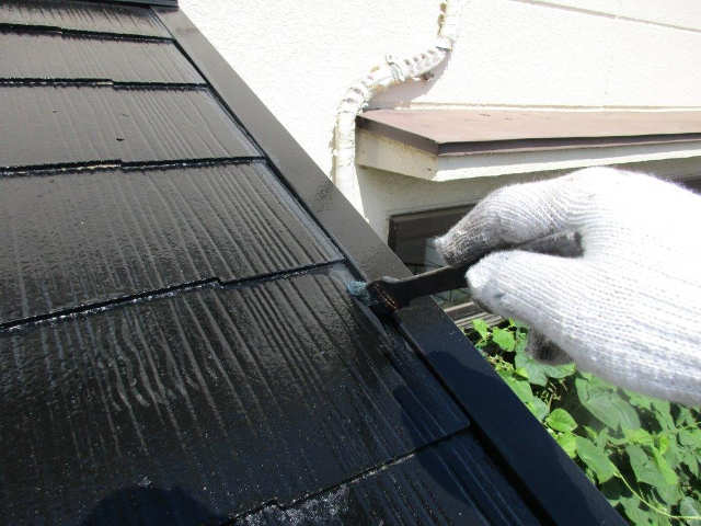 中塗りをハケで塗装中の屋根