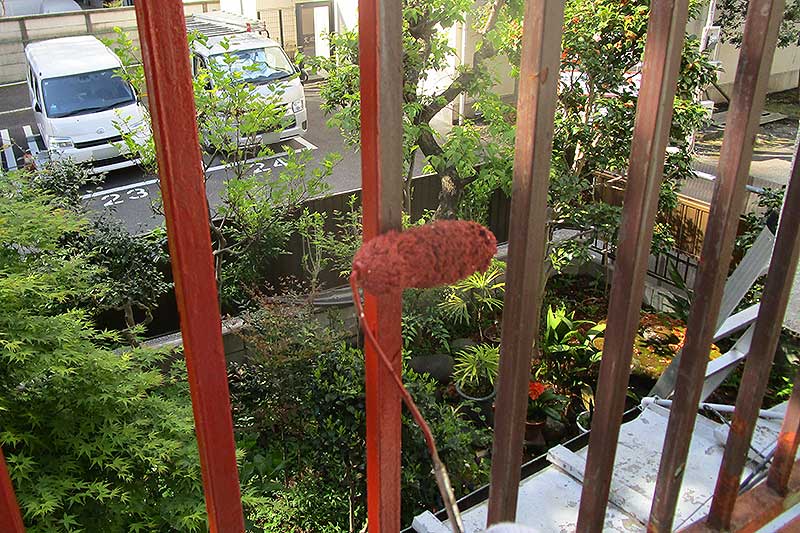 ローラーを使用したベランダ手摺りの錆止め塗装作業