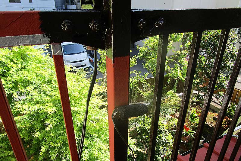 ローラーを使用したベランダ手摺りの上塗り作業