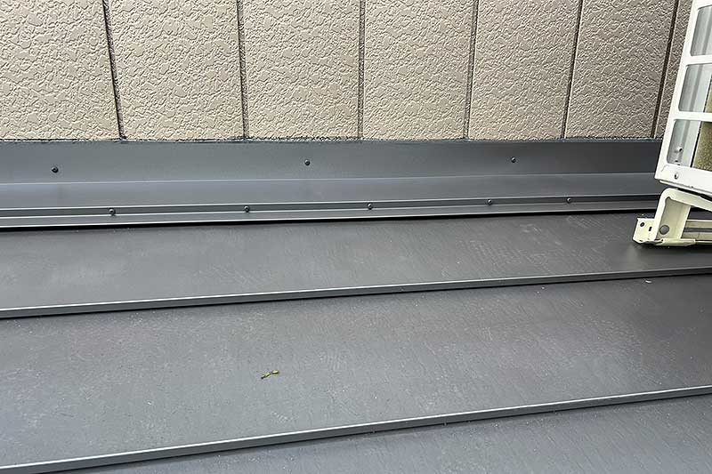 壁際に雨押え板金材を取付けてコーキング処理