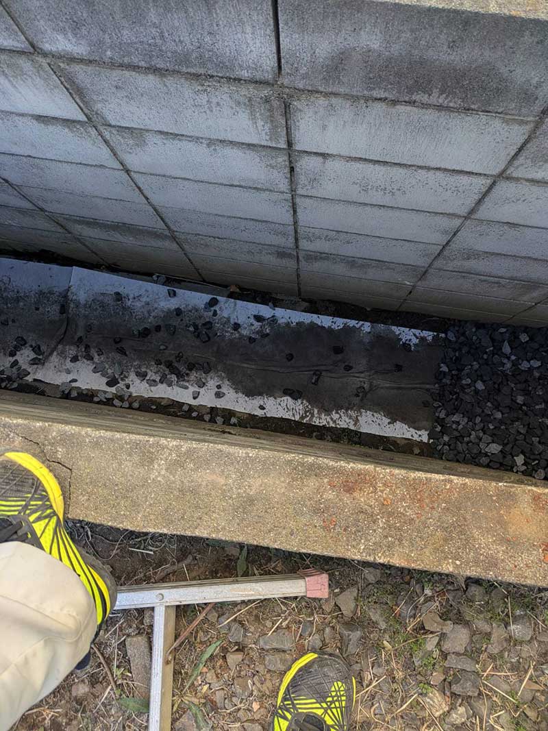 擁壁横の水路のコンクリート蓋の上に敷設した透水シート