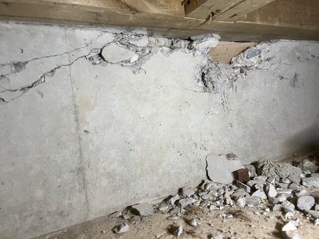 基礎上部にひび割れや欠けがあり、床下に破片が落ちている状態